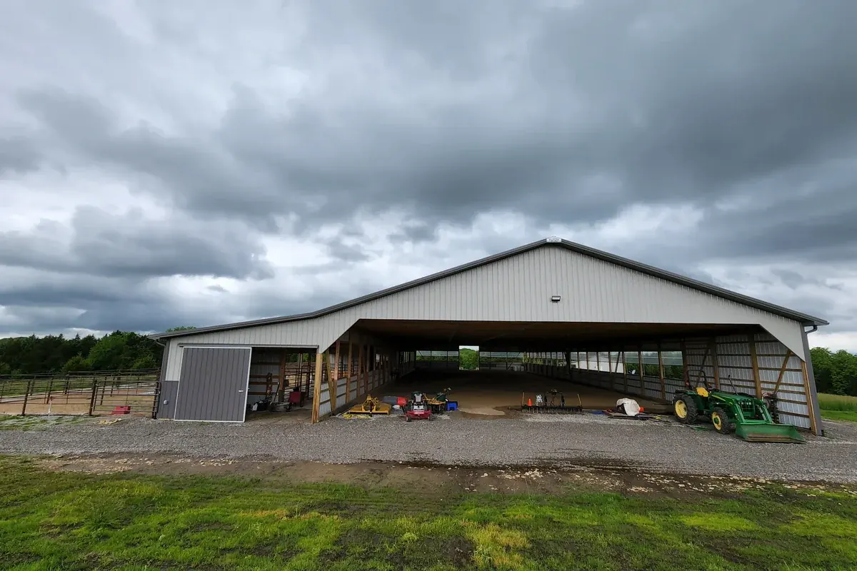 Open-sided pole barn with visible post and truss framing