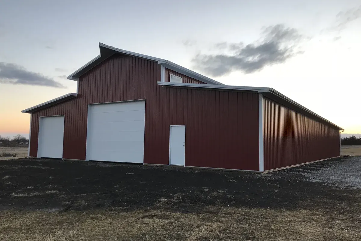 Finished red and white pole barn at dusk