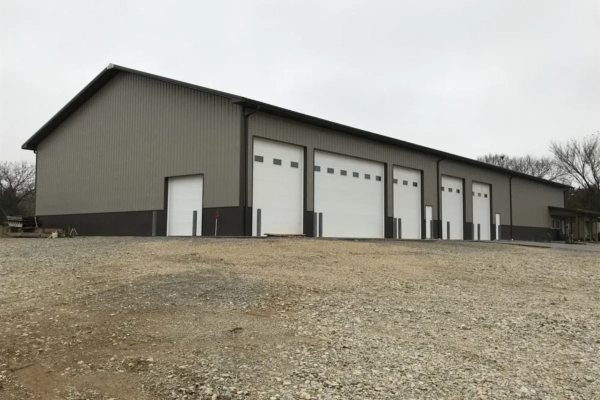 Large tan commercial pole barn with five matching overhead doors
