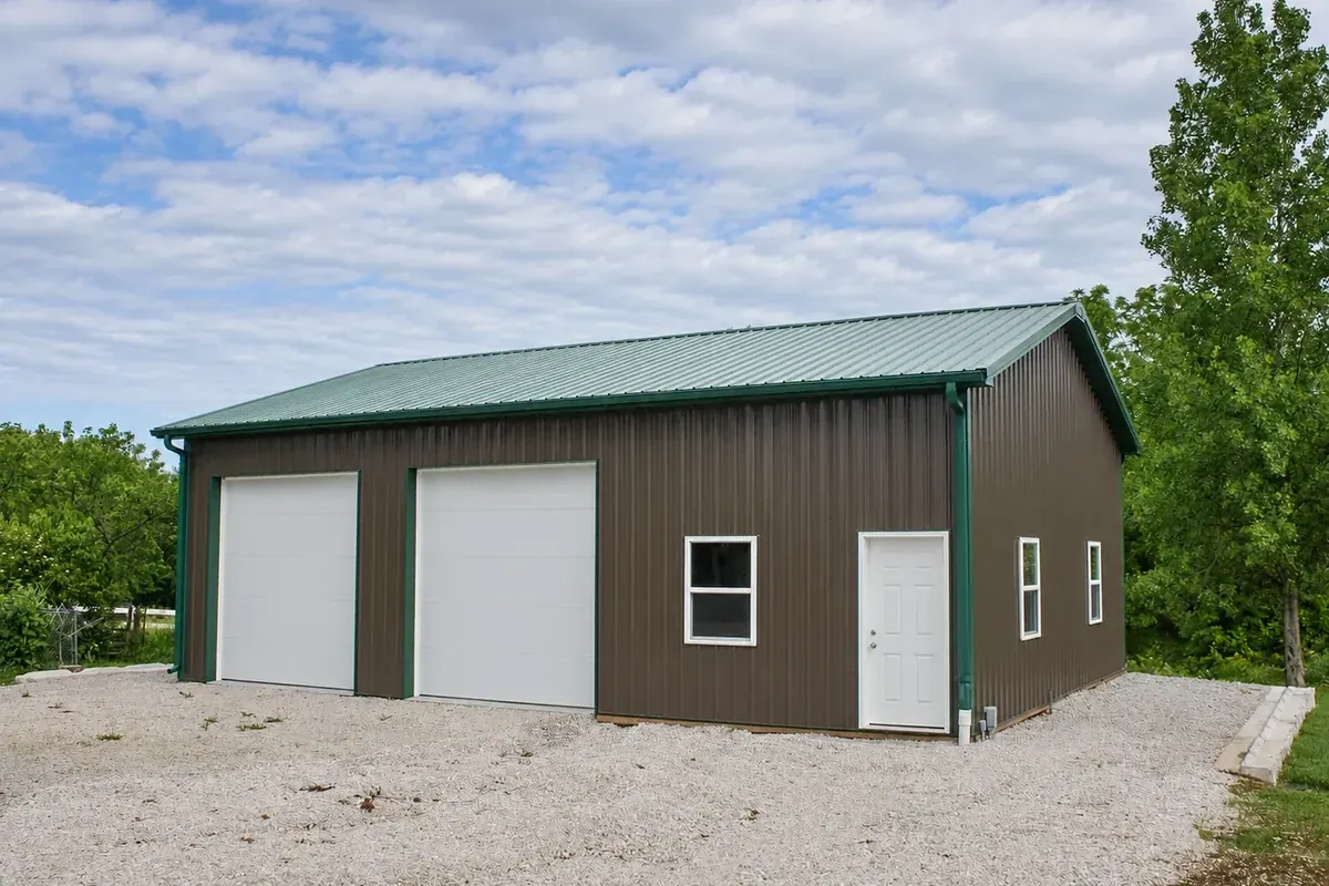 Brown two-car garage with green trim and roof