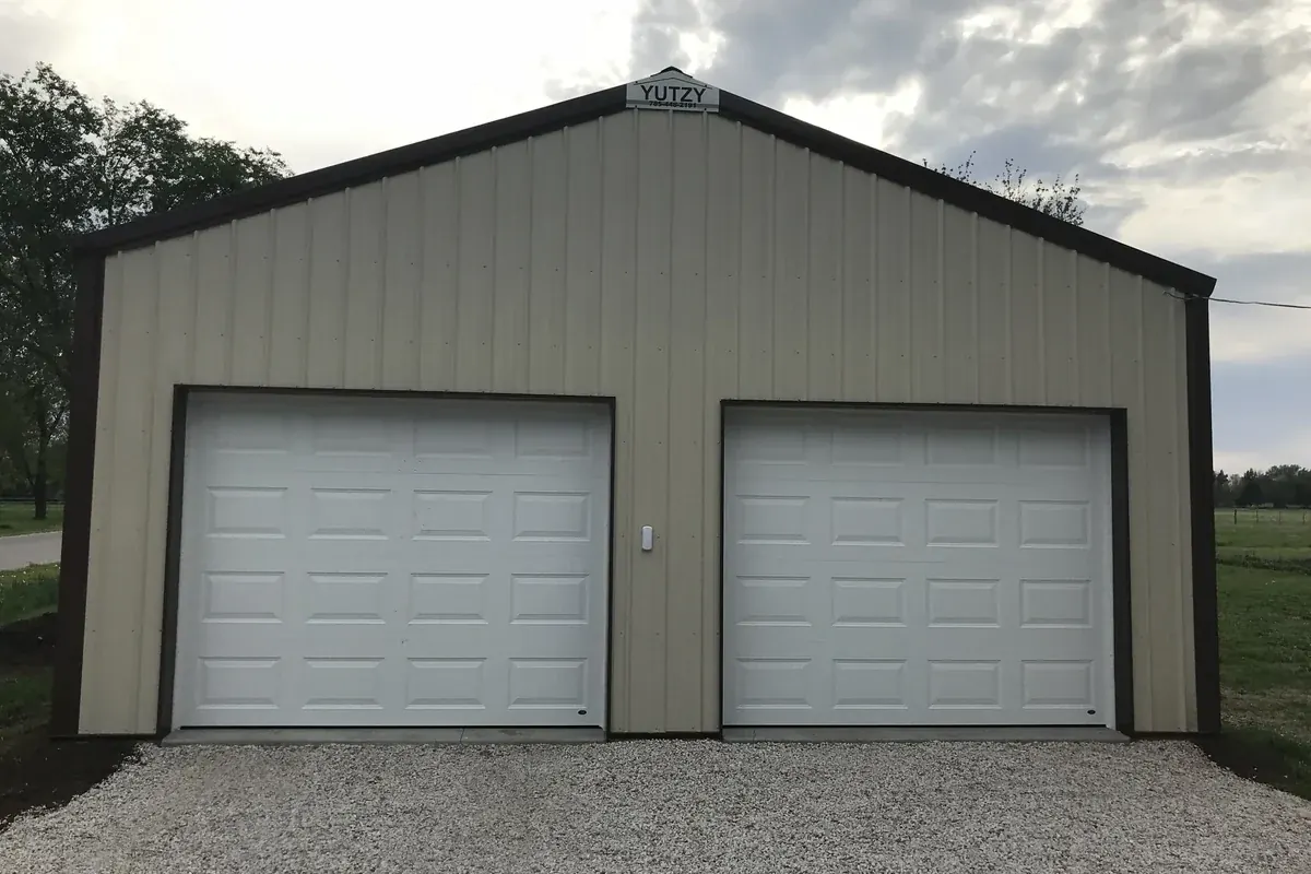 Tan and brown two-car garage with a Yutzy nameplate on the peak
