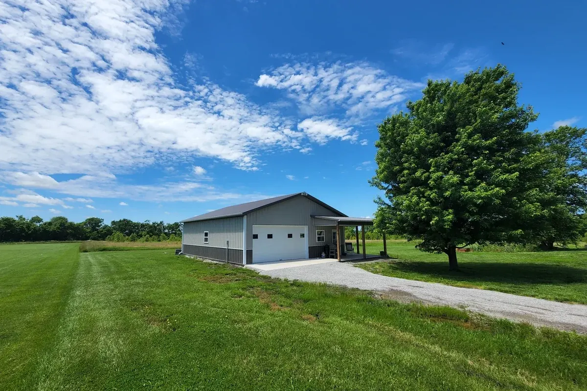 Gray and white hobby shop with a covered sitting porch