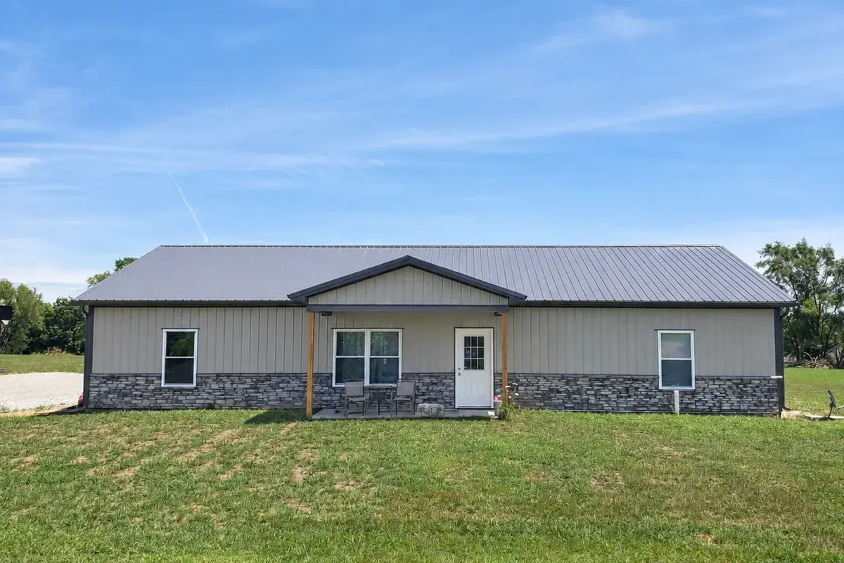 Tan custom home with stone wainscoting and a covered gable entry