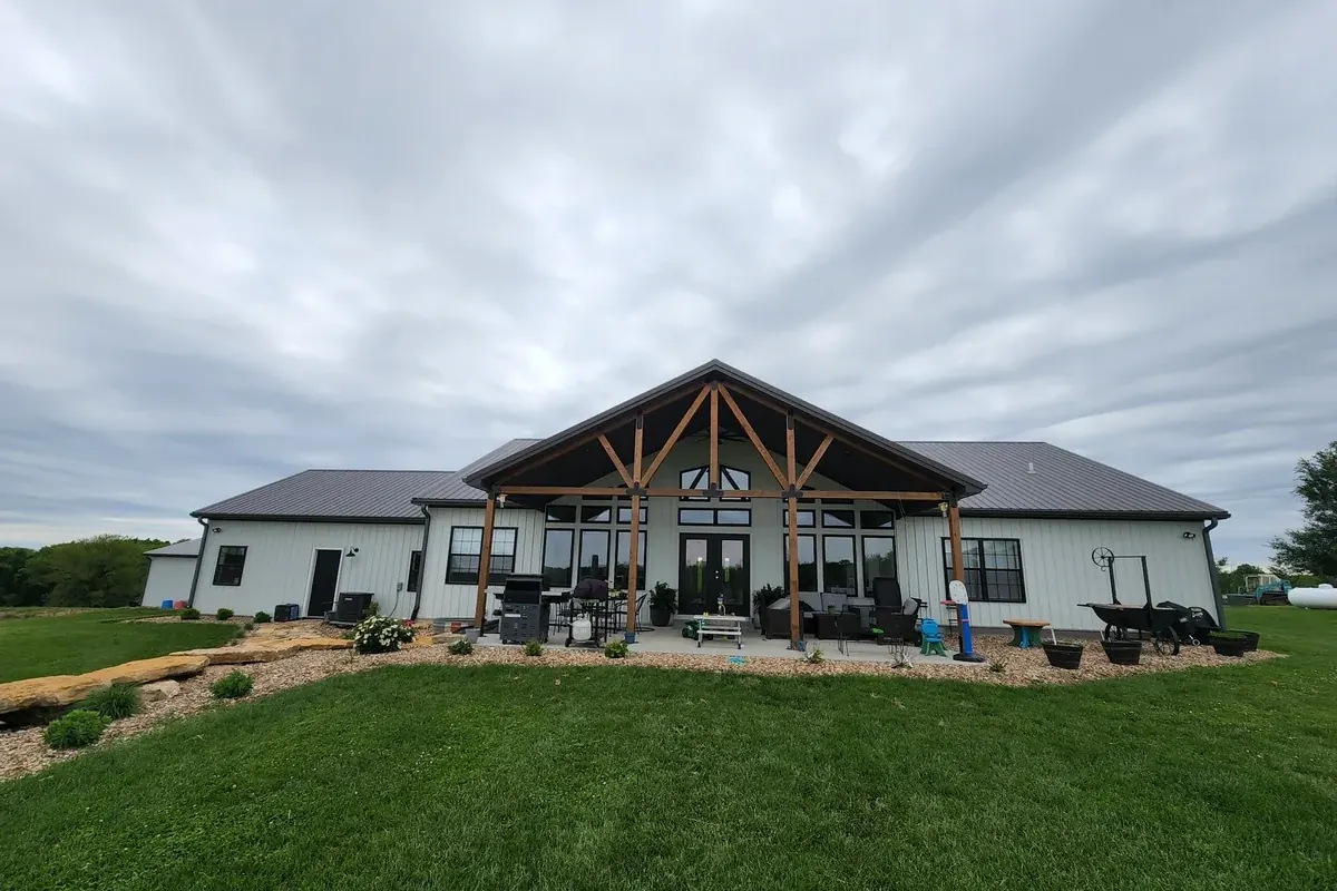 White custom home with a timber-frame covered patio and ceiling fan