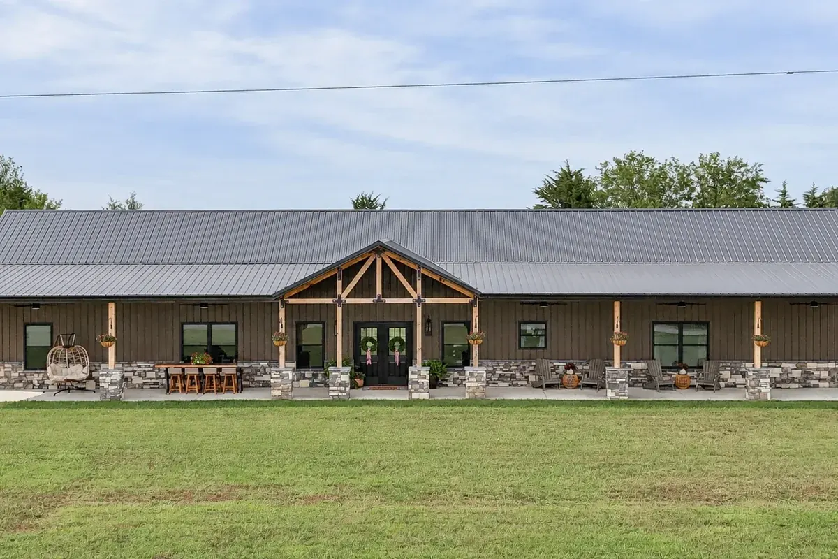 Elegant custom home with a stone-columned covered porch and timber-frame entry