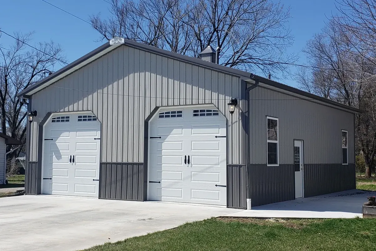 Gray hobby shop with two white overhead doors and a Yutzy nameplate on the peak