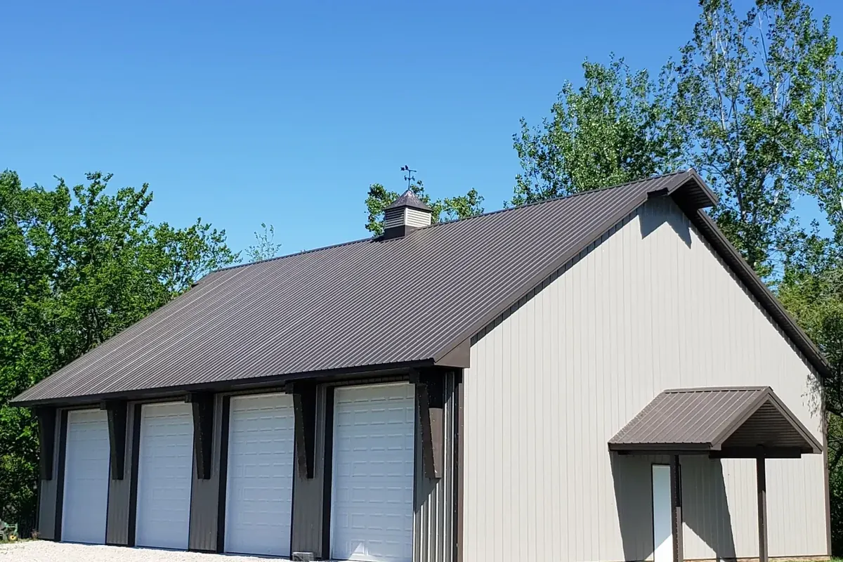 Four-bay post-frame garage with a dark brown roof and a covered side entry